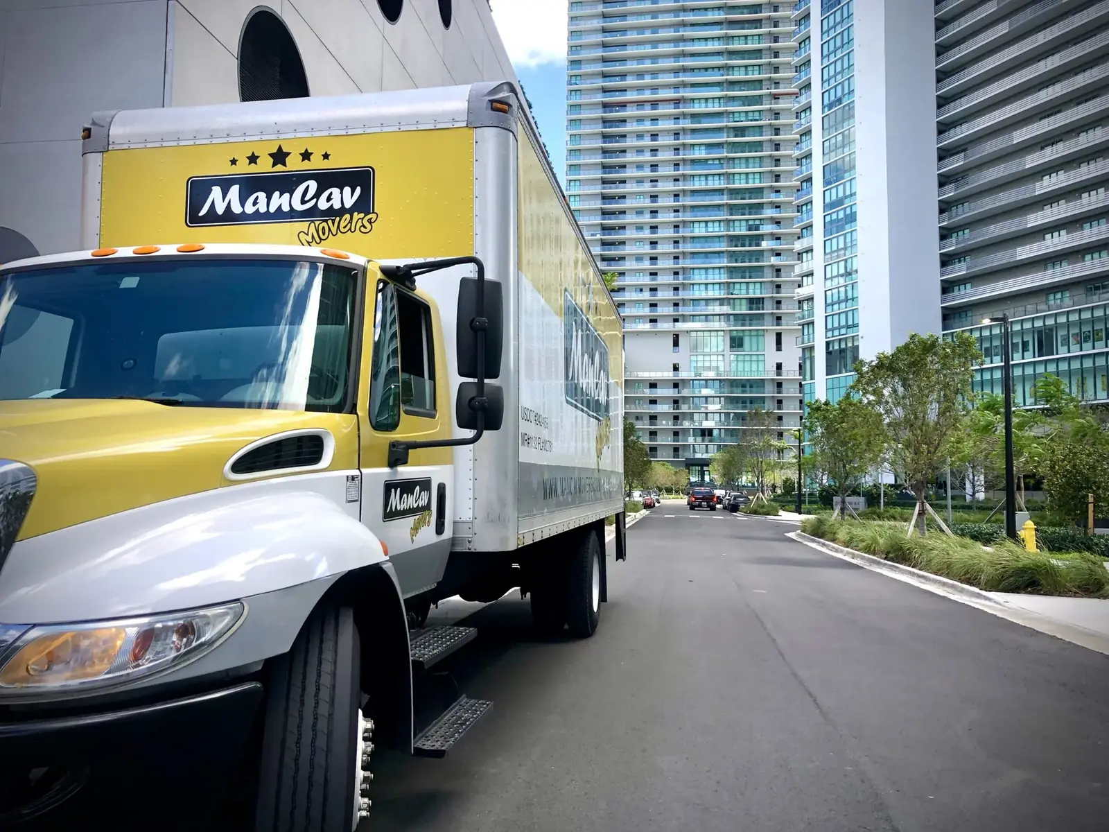 ManCav Movers truck parked on Biscayne Blvd in Miami with high-rises behind