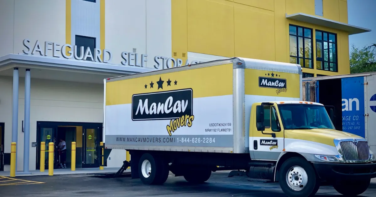 ManCav Movers truck at a self storage facility with USDOT and Florida mover numbers on the side